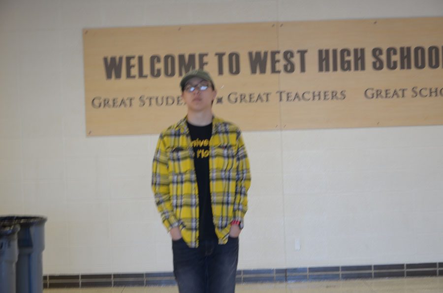 Noah Krchak(19) waits patiently for his photo to be taken in front of the west high sign
