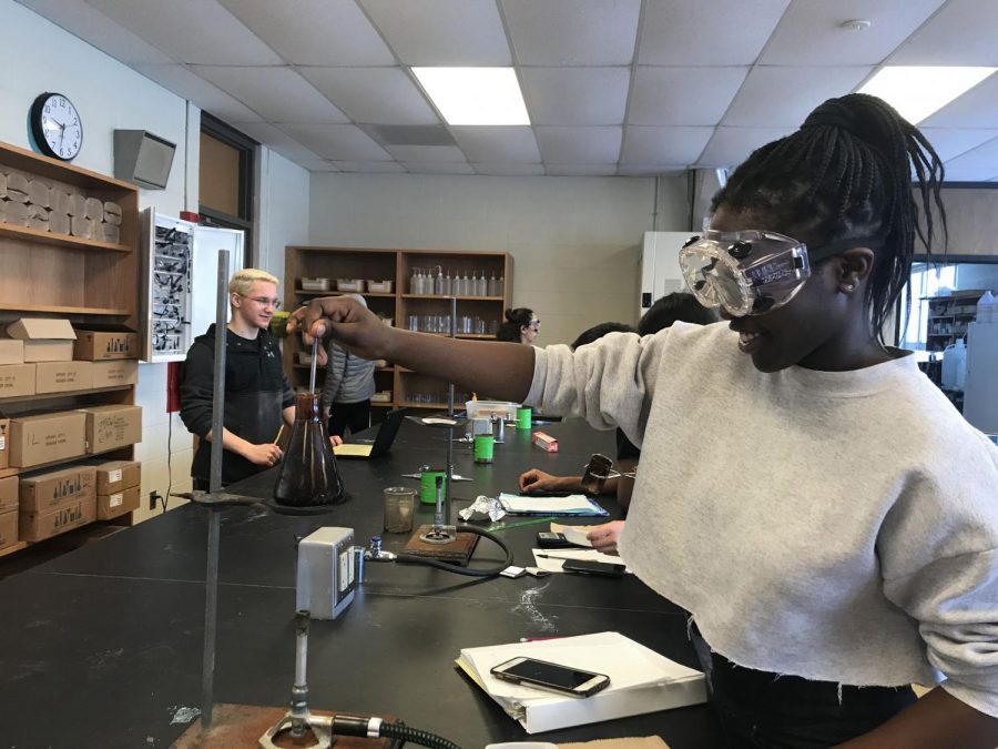 Favour Alarape ’21 watches over her bunsen burner in a chemistry lab. Her goal is to prevent the popcorn from burning.